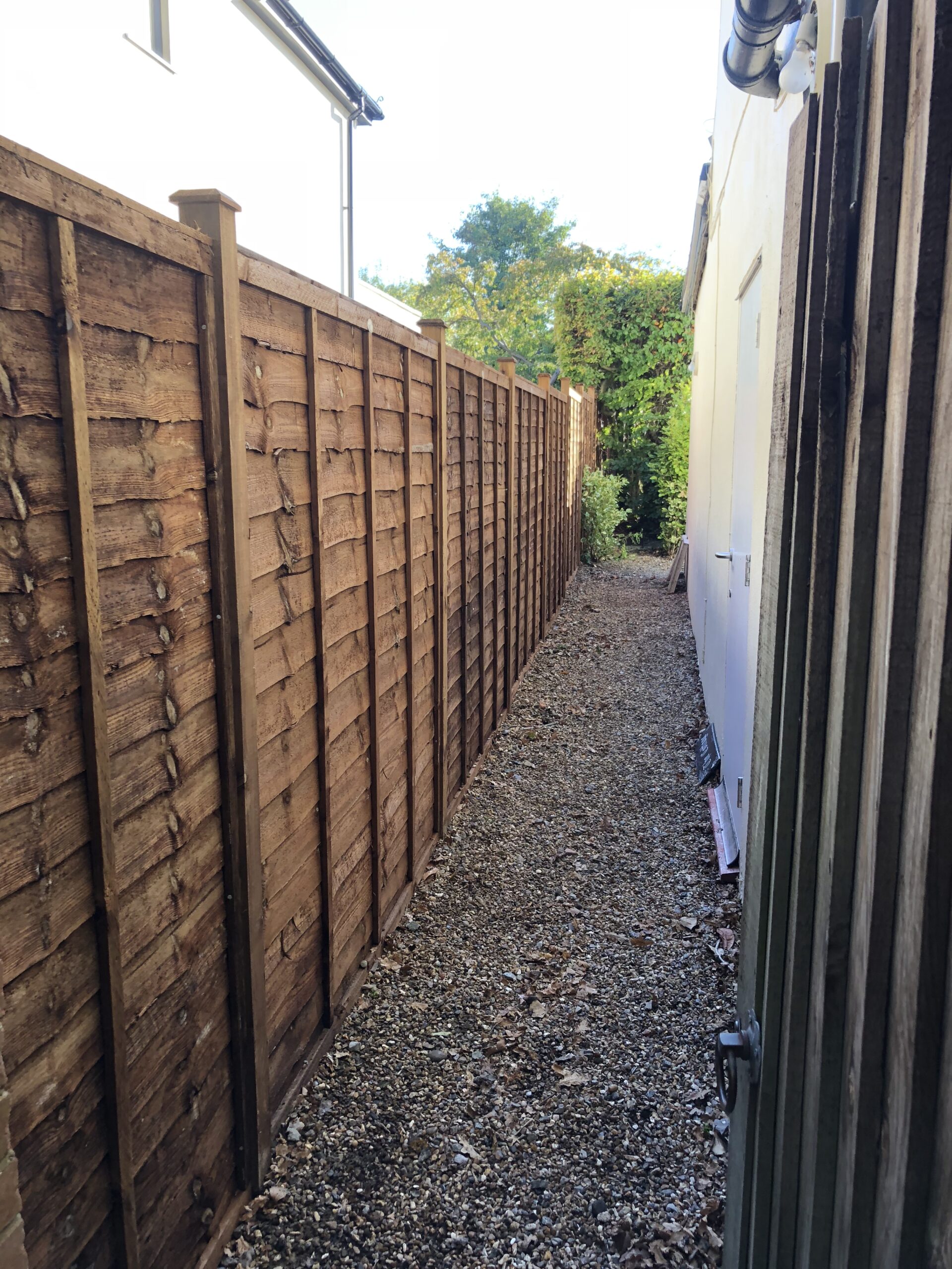 A run of brown overlap panels with timber posts and post caps