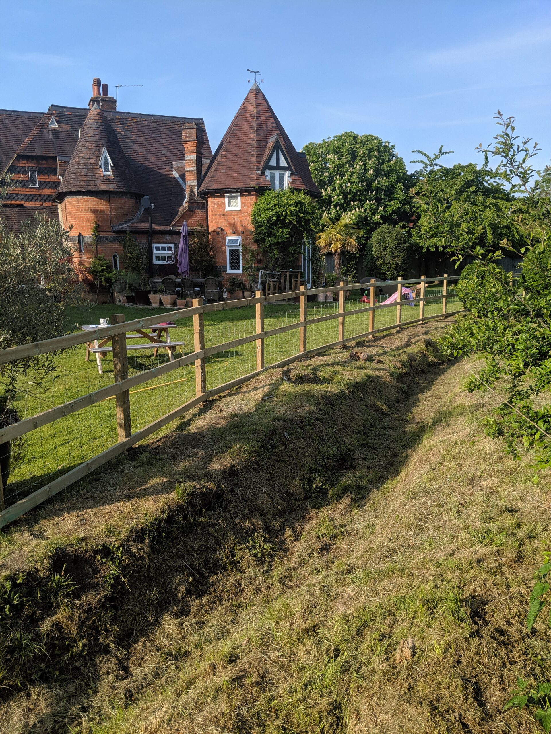 posts and rail with stock wire with old house in background